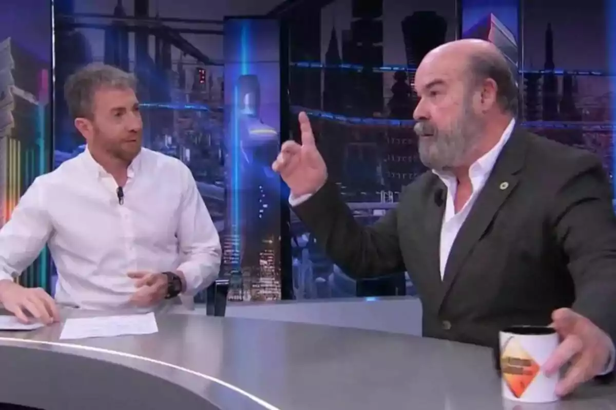 Pablo Motos y Antonio Resines conversan en El Hormiguero; uno de ellos gesticula mientras sostiene una taza.