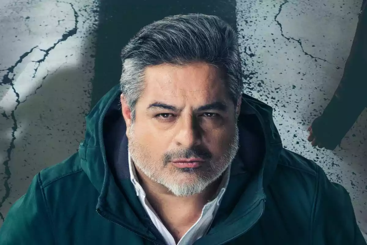 Jalis de la Serna de cabello canoso y barba mira intensamente a la cámara, vistiendo una chaqueta verde con capucha, sobre un fondo de suelo agrietado en Apatrullando.