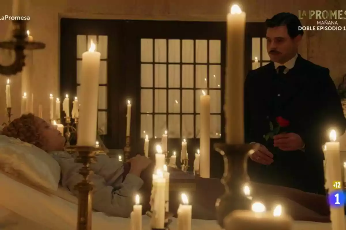 Una escena con Ana Garcés acostada rodeada de velas encendidas y Arturo Sancho de pie sosteniendo una rosa roja en La Promesa. Una escena con Ana Garcés acostada rodeada de velas encendidas y Arturo Sancho de pie sosteniendo una rosa roja en La Promesa.
