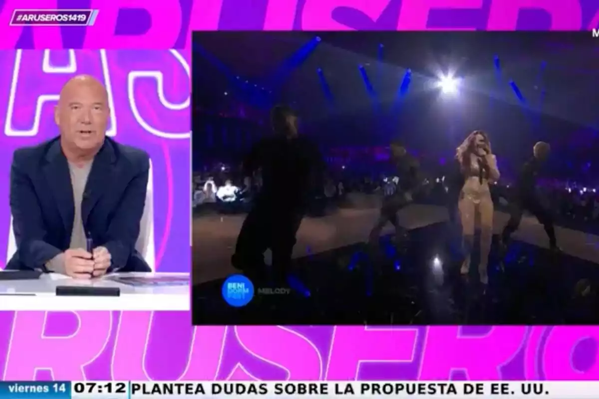 Alfonso Arús está sentado en un estudio en el programa 'Aruser@s' mientras en una pantalla se muestra a una cantante actuando en un escenario con luces brillantes y bailarines. Alfonso Arús está sentado en un estudio en el programa 'Aruser@s' mientras en una pantalla se muestra a una cantante actuando en un escenario con luces brillantes y bailarines.