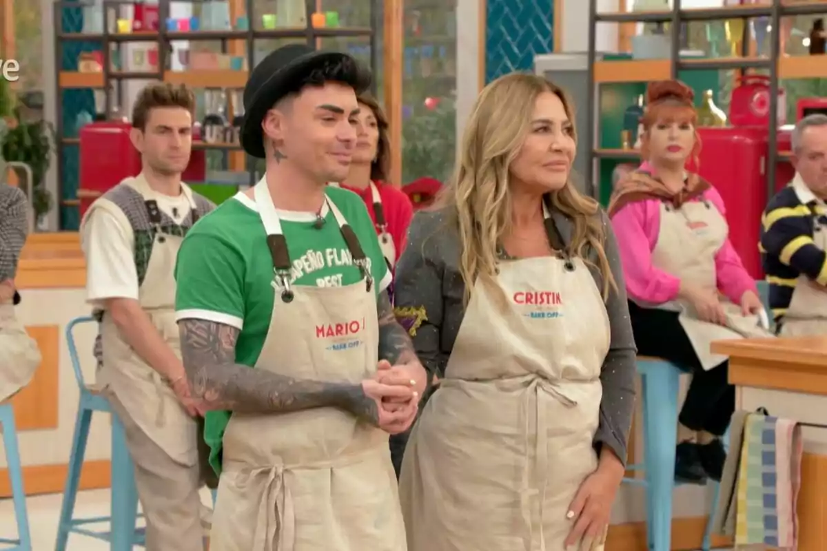 Mario Jefferson y Cristina Tárrega con delantales participa en Bake Off: famosos al horno en un estudio colorido. Mario Jefferson y Cristina Tárrega con delantales participa en Bake Off: famosos al horno en un estudio colorido.