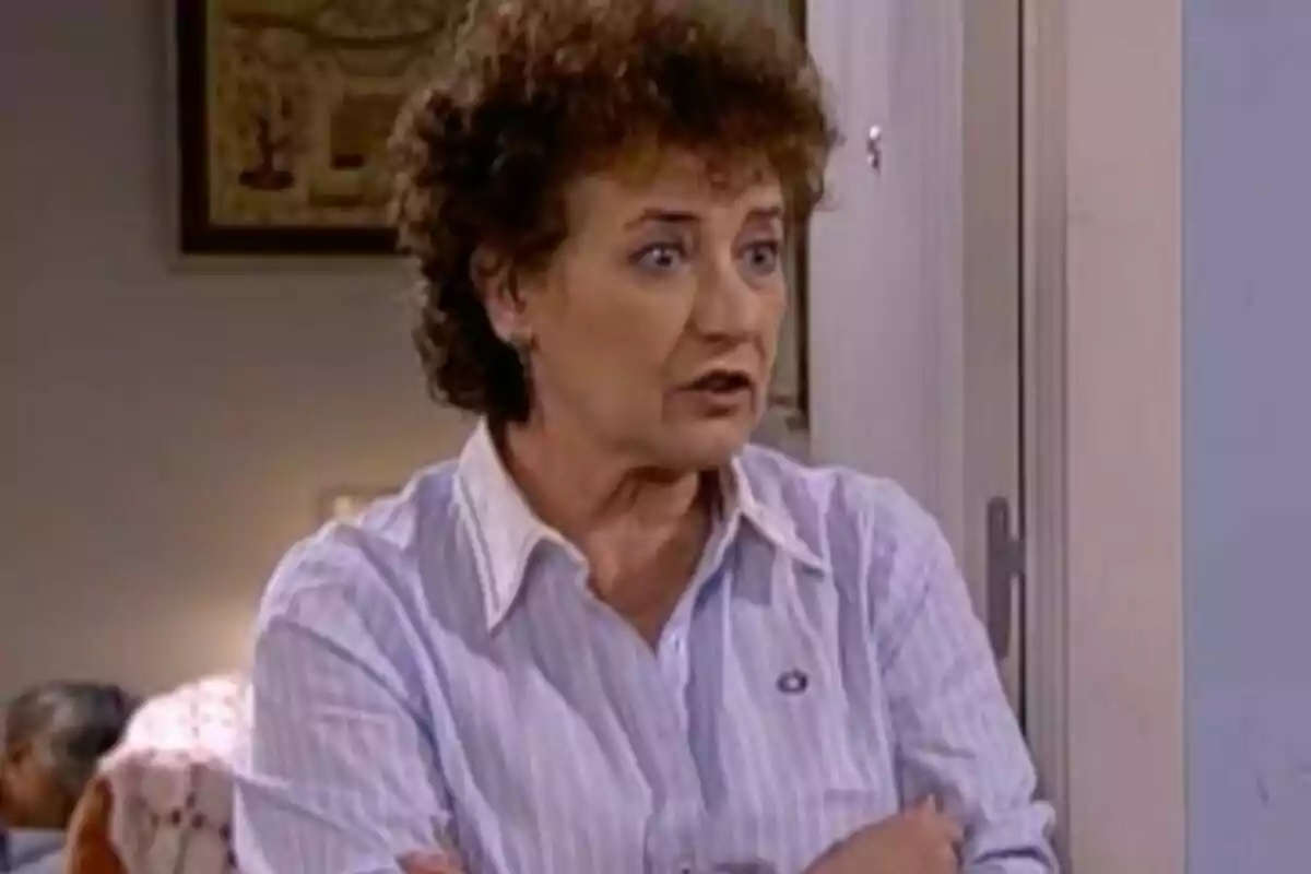 Beatriz Carvajal de cabello rizado y expresión seria está de pie con los brazos cruzados en una habitación en La que se avecina. Beatriz Carvajal de cabello rizado y expresión seria está de pie con los brazos cruzados en una habitación en La que se avecina.