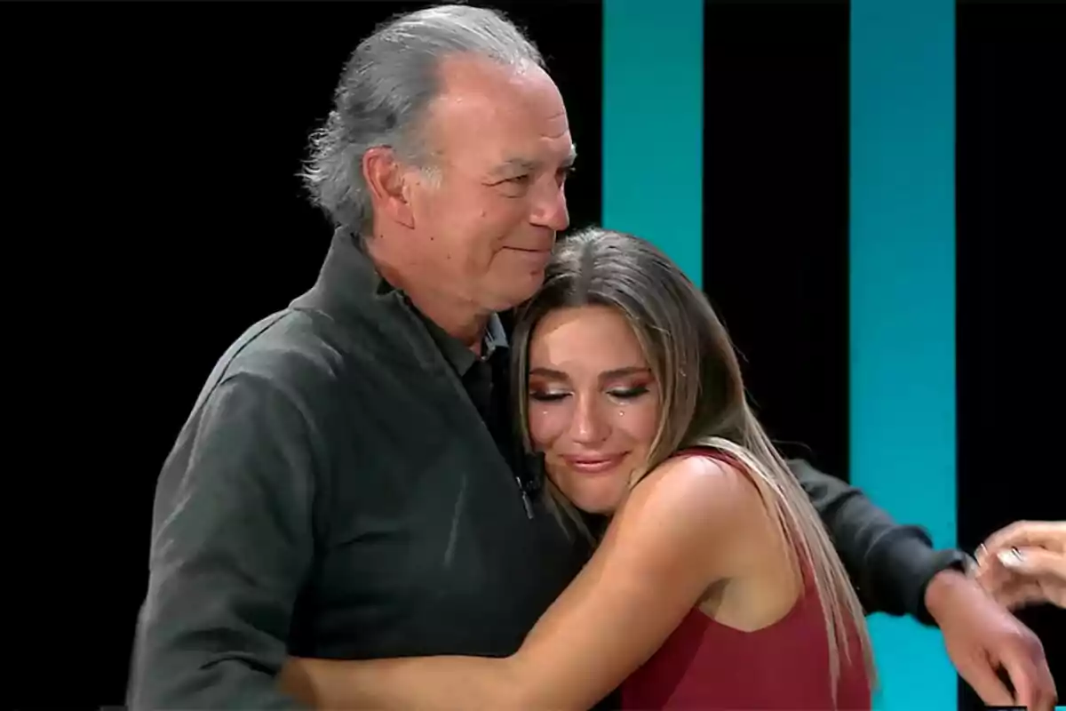 Bertín Osborne y Laura Gallego se abrazan con emoción en un entorno iluminado en El Show de Bertín. Bertín Osborne y Laura Gallego se abrazan con emoción en un entorno iluminado en El Show de Bertín.