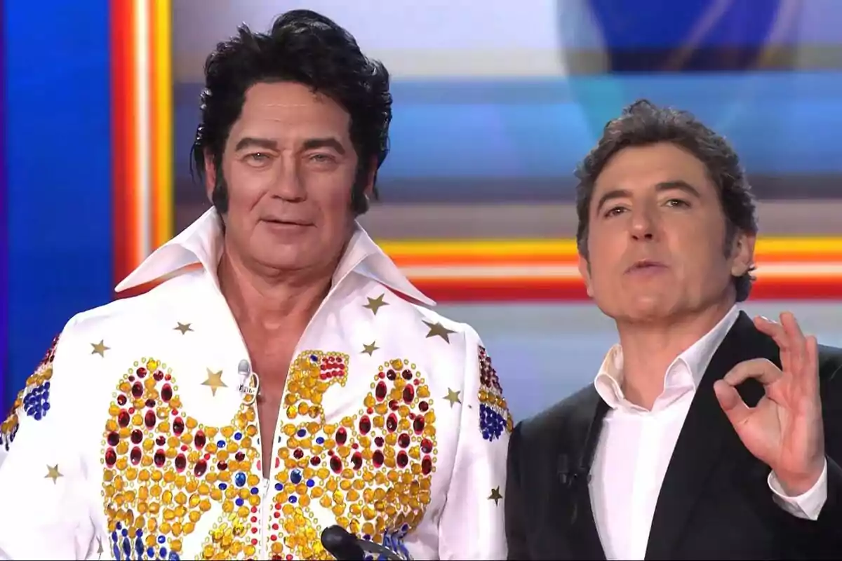 Dos hombres posan juntos, Bertín Osborne lleva un traje blanco con adornos brillantes y Manel Fuentes viste un traje oscuro, en Tu Cara Me Suena. Dos hombres posan juntos, Bertín Osborne lleva un traje blanco con adornos brillantes y Manel Fuentes viste un traje oscuro, en Tu Cara Me Suena.