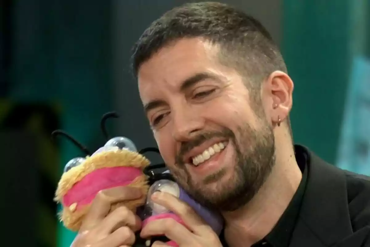 David Btoncano sonriente abrazando un muñeco de peluche colorido, las hormigas de 'El Hormiguero'. David Btoncano sonriente abrazando un muñeco de peluche colorido, las hormigas de 'El Hormiguero'.