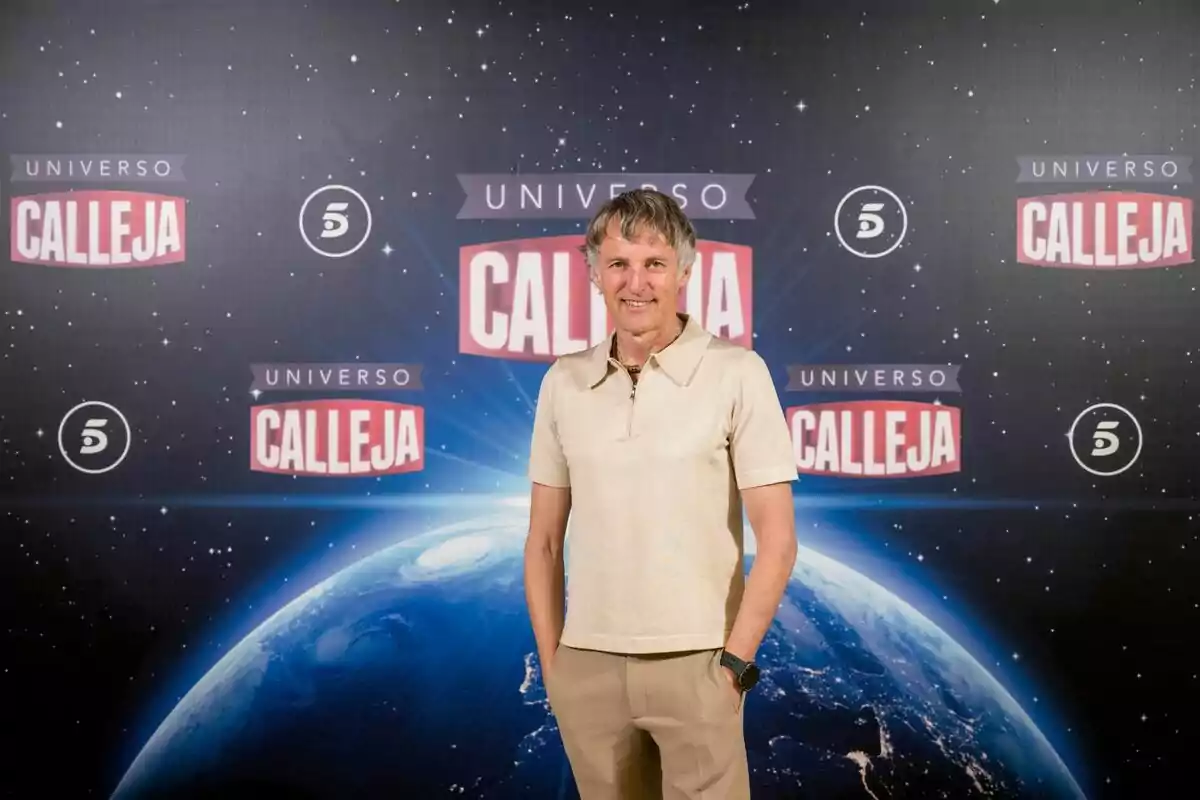Jesús Calleja de pie frente a un fondo con temática espacial y logotipos de Jesús Calleja de pie frente a un fondo con temática espacial y logotipos de