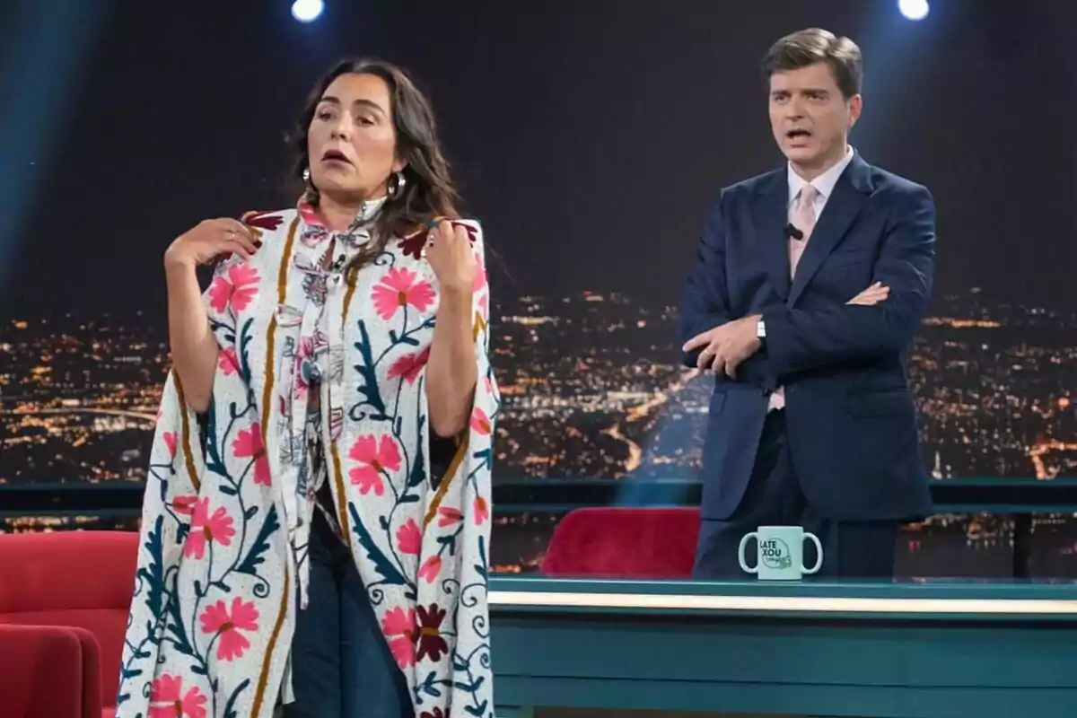 Dos personas en Late Xou, Candela Peña con un poncho colorido y Marc Giró con traje oscuro, ambos parecen estar en una conversación animada. Dos personas en Late Xou, Candela Peña con un poncho colorido y Marc Giró con traje oscuro, ambos parecen estar en una conversación animada.