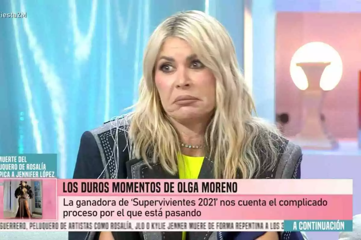 Ana Luque con expresión seria está sentada en 'Fiesta', con un texto en pantalla que menciona Ana Luque con expresión seria está sentada en 'Fiesta', con un texto en pantalla que menciona
