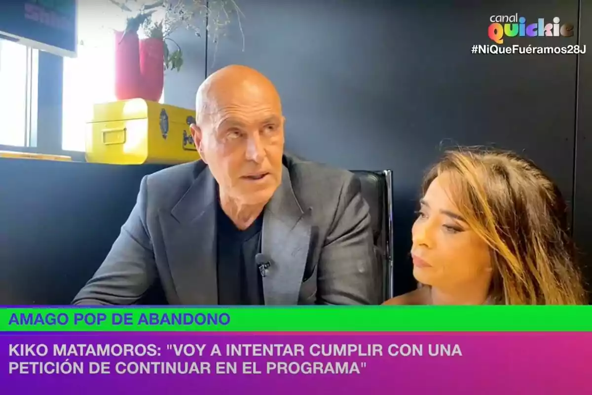 En la imagen se observa a dos personas sentadas en un estudio de televisión, con un rótulo que dice En la imagen se observa a dos personas sentadas en un estudio de televisión, con un rótulo que dice