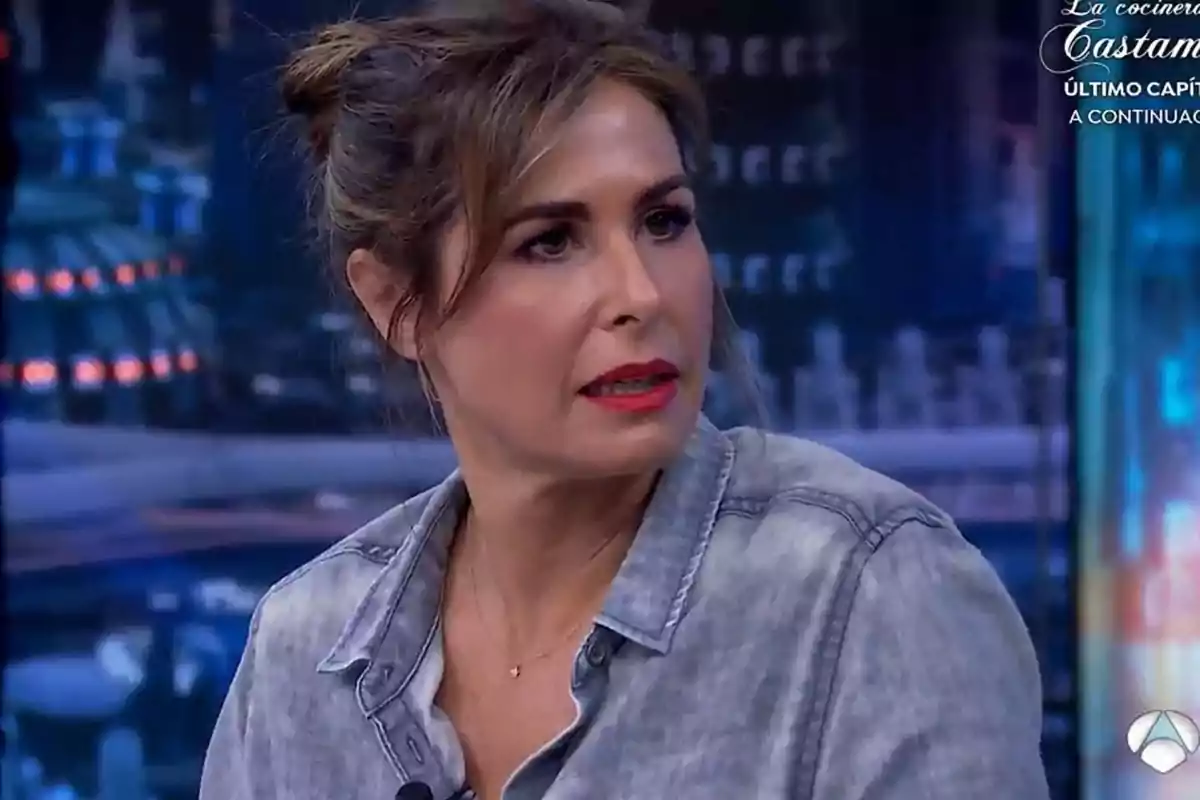 Núria Roca con camisa de mezclilla y cabello recogido, con expresión seria, en un set de televisión con fondo desenfocado. Núria Roca con camisa de mezclilla y cabello recogido, con expresión seria, en un set de televisión con fondo desenfocado.