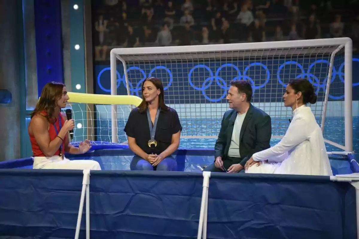 Carlos Latre y Marta Torné entrevistando a dos medaillistas en una piscina inflable, con una portería y los anillos olímpicos de fondo en Babylon Show. Carlos Latre y Marta Torné entrevistando a dos medaillistas en una piscina inflable, con una portería y los anillos olímpicos de fondo en Babylon Show.