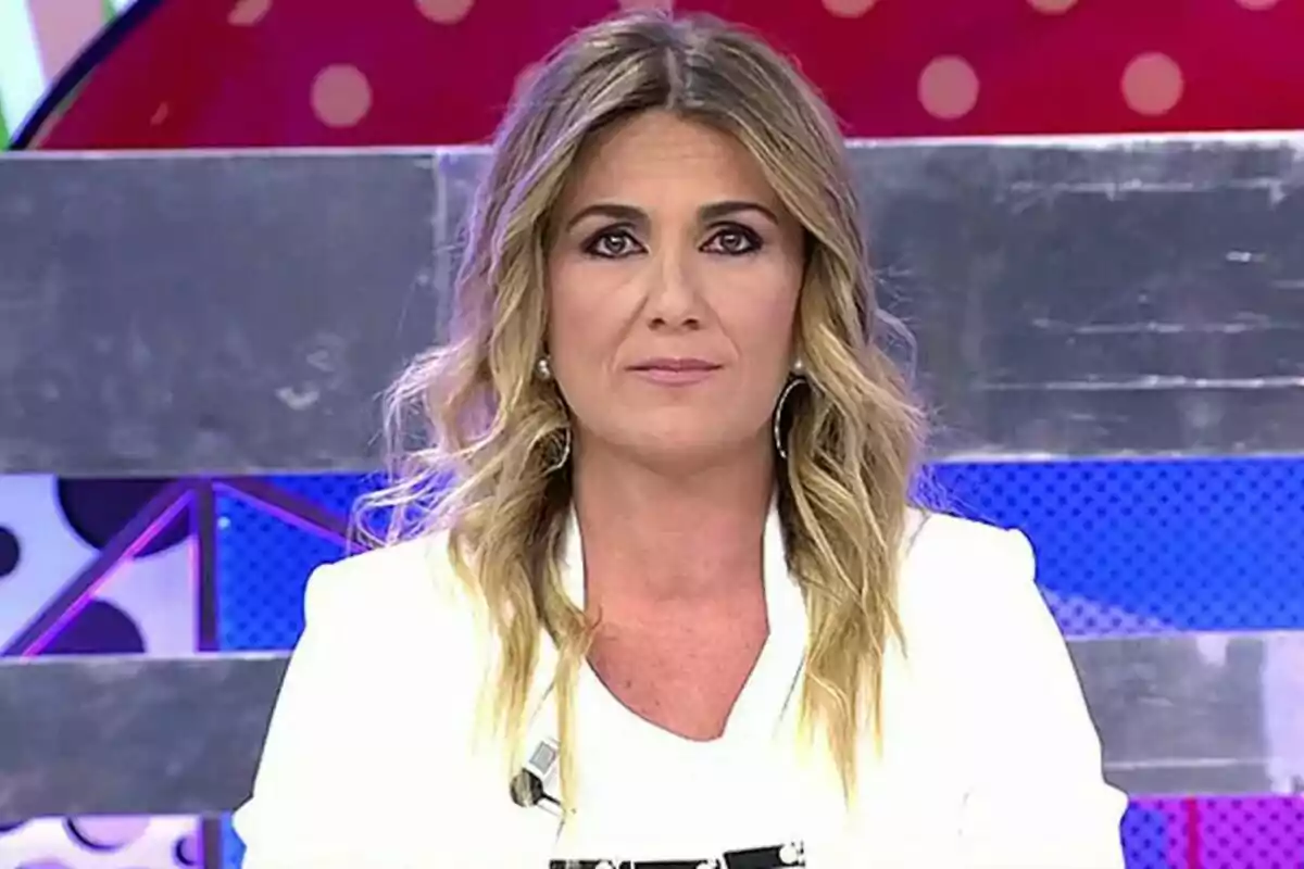 Carlota Corredera amb cabell ros i ondulat en un estudi de televisió amb fons colorit.