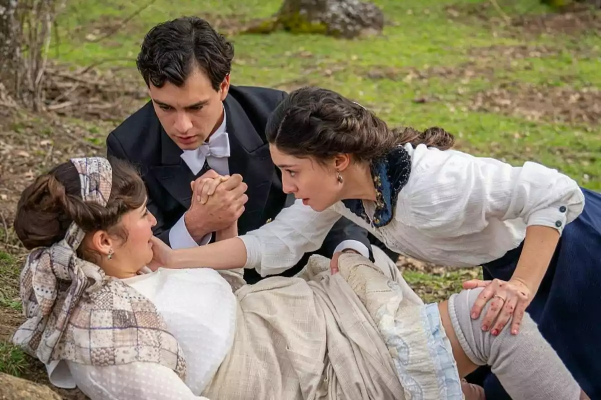 Carmen Asecas, Xavi Lock y Marta Costa en un entorno al aire libre, dos de ellas están ayudando a una mujer que parece estar herida o en apuros en La Promesa. Carmen Asecas, Xavi Lock y Marta Costa en un entorno al aire libre, dos de ellas están ayudando a una mujer que parece estar herida o en apuros en La Promesa.