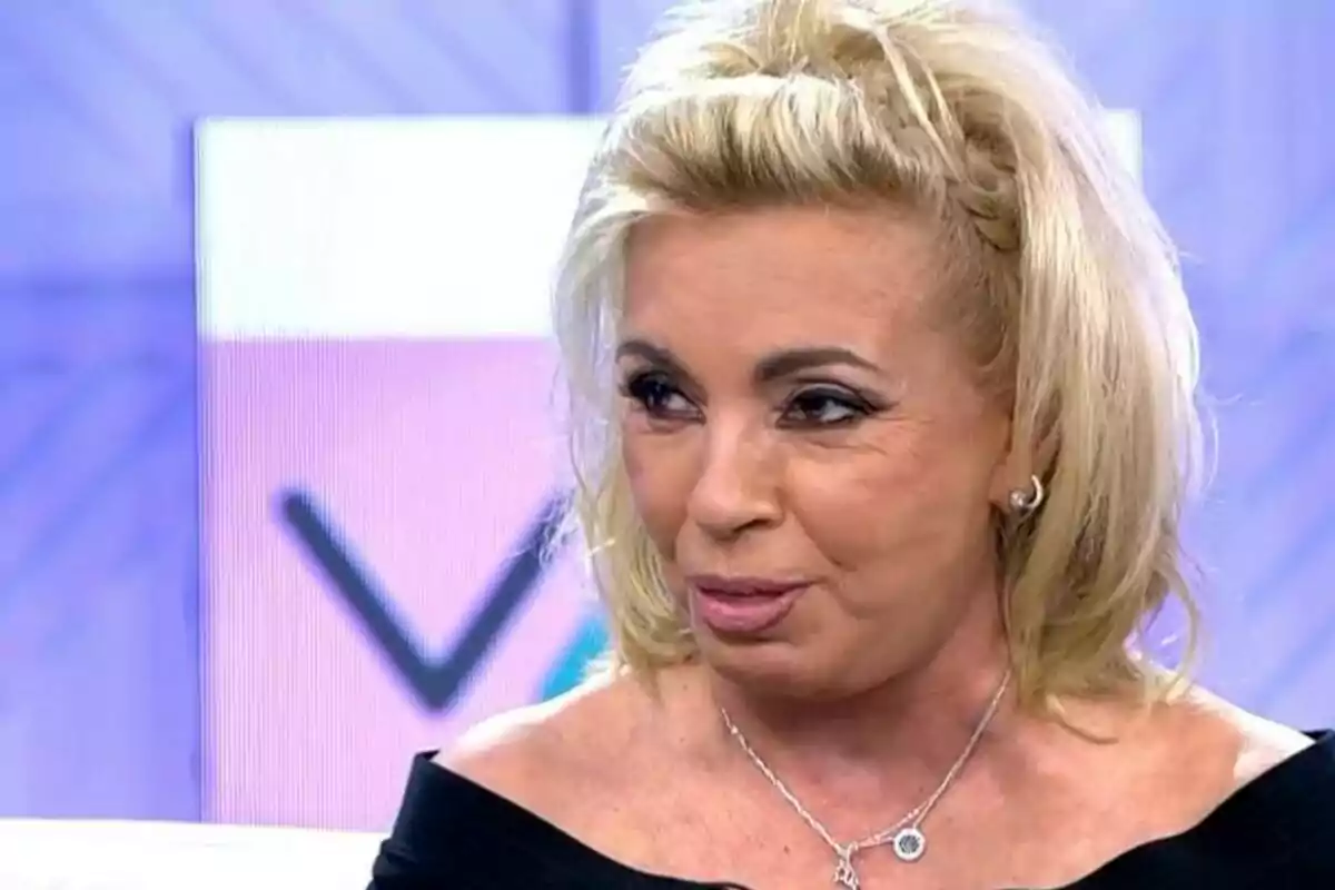 Plànol curt de Carmen Borrego amb cabell ros i maquillatge, usant un collaret i anells, en un entorn d'estudi de televisió. Plànol curt de Carmen Borrego amb cabell ros i maquillatge, usant un collaret i anells, en un entorn d'estudi de televisió.