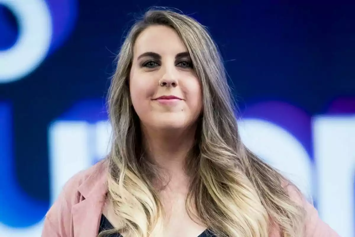 Carolina Iglesias a con cabello largo y rubio oscuro sonriendo frente a un fondo azul. Carolina Iglesias a con cabello largo y rubio oscuro sonriendo frente a un fondo azul.