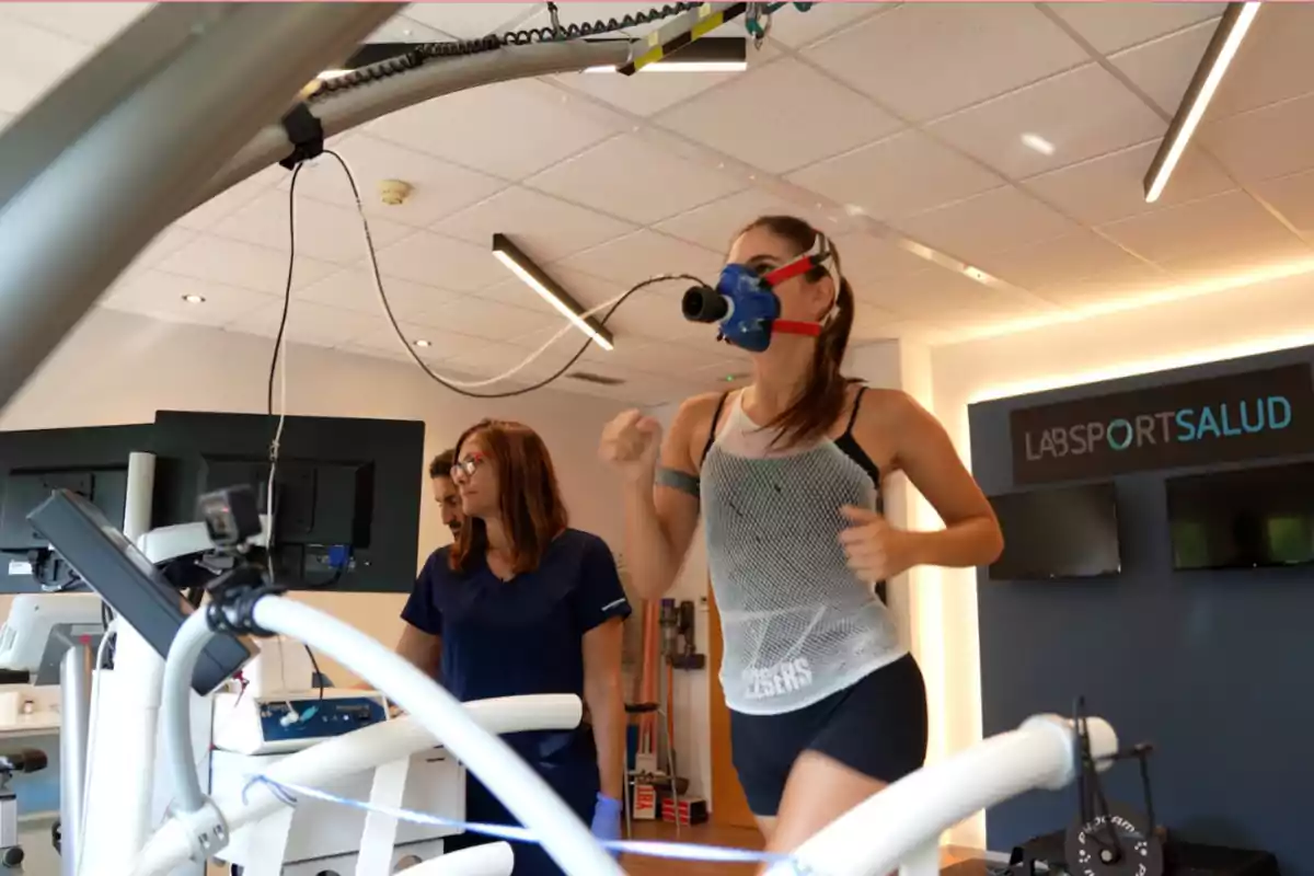 Celia Espanya corre en una cinta de correr con una máscara de oxígeno mientras es observada por personal médico en un laboratorio de salud. Celia Espanya corre en una cinta de correr con una máscara de oxígeno mientras es observada por personal médico en un laboratorio de salud.