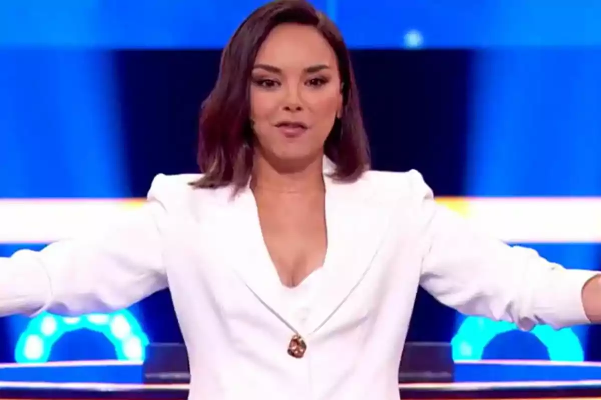 Chenoa amb vestit blanc en un escenari il·luminat de The Floor. Chenoa amb vestit blanc en un escenari il·luminat de The Floor.