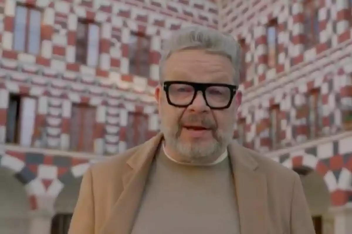 Alberto Chicote con gafas y barba está de pie frente a un edificio con un diseño geométrico en rojo y blanco. Alberto Chicote con gafas y barba está de pie frente a un edificio con un diseño geométrico en rojo y blanco.