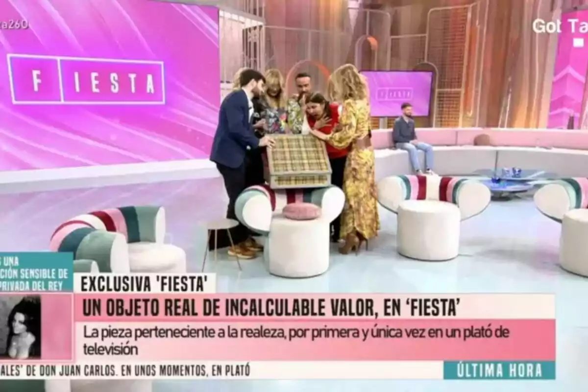 Un grupo de colaboradores de Fiesta de Emma García como Belén Rodríguez o Luis Rollán observan un objeto cubierto con tela a cuadros, mientras en la pantalla se lee Un grupo de colaboradores de Fiesta de Emma García como Belén Rodríguez o Luis Rollán observan un objeto cubierto con tela a cuadros, mientras en la pantalla se lee