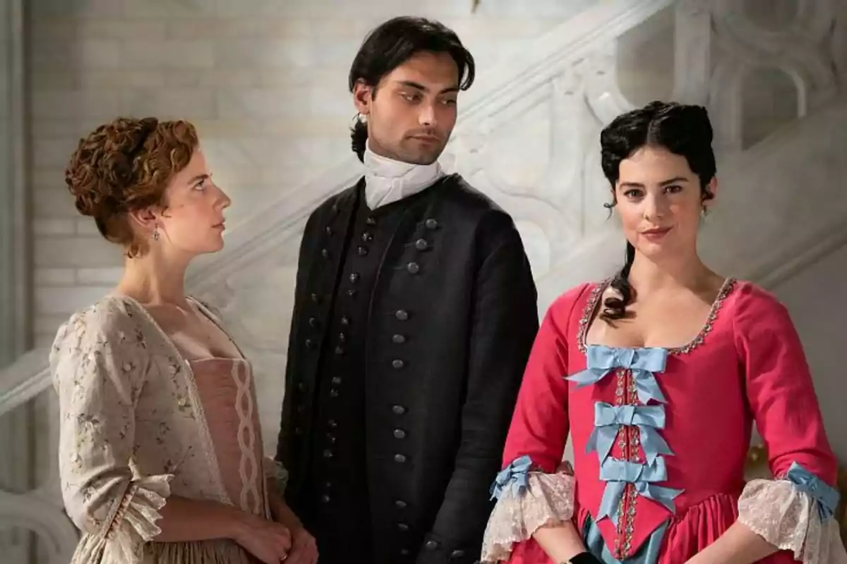 Rocio Suárez de Puga, Marco Pernas i Cristina Abad vestides amb vestits d'època posen en un ambient elegant amb una escala de fons a Valle Salvaje.