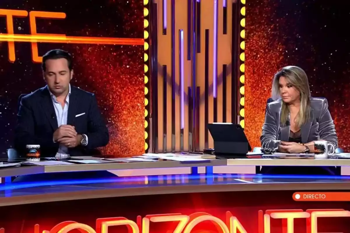 Iker Jiménez i Carmen Portero assegudes en un plató de televisió amb un fons il·luminat i la paraula Iker Jiménez i Carmen Portero assegudes en un plató de televisió amb un fons il·luminat i la paraula