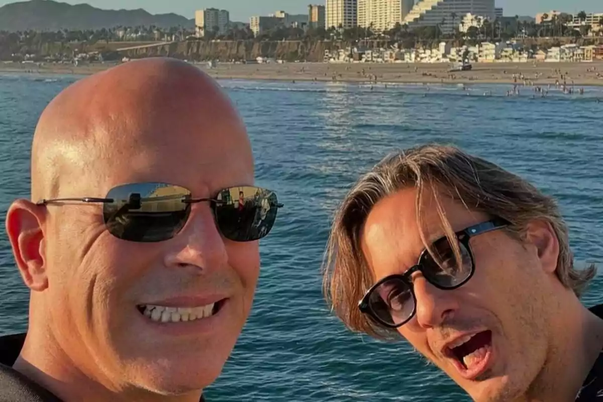 Alberto Caballero junto a Daniel Deorador con gafas de sol posan para una selfie frente al mar con una ciudad y montañas al fondo. Alberto Caballero junto a Daniel Deorador con gafas de sol posan para una selfie frente al mar con una ciudad y montañas al fondo.