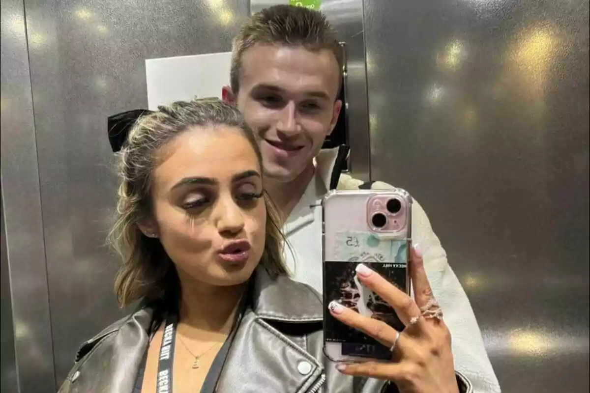 Fotografía de Daniel Duffield con su novia tomándose una selfie en un ascensor, la mujer está haciendo un gesto con los labios mientras sostiene el teléfono. Fotografía de Daniel Duffield con su novia tomándose una selfie en un ascensor, la mujer está haciendo un gesto con los labios mientras sostiene el teléfono.