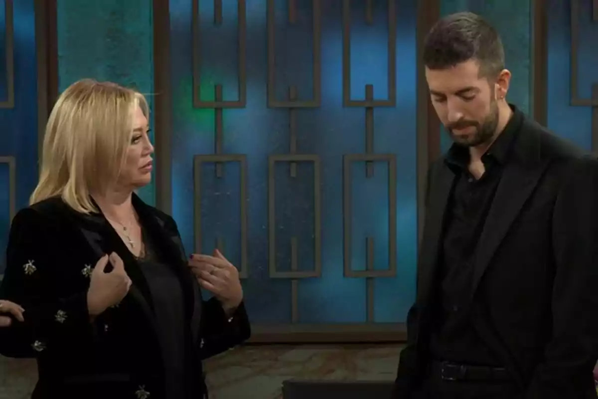 Belén Esteban y David Broncano vestidas de negro están de pie en un ambiente con fondo azul y decoraciones geométricas en La Revuelta. Belén Esteban y David Broncano vestidas de negro están de pie en un ambiente con fondo azul y decoraciones geométricas en La Revuelta.