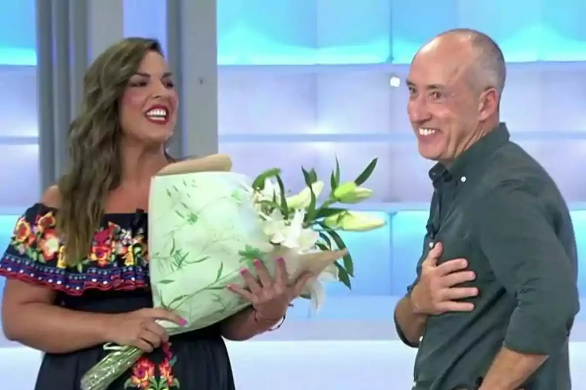 Adriana Dorronsoro somrient sosté un ram de flors al plató de Vamos a ver mentre Alfonso Egea al seu costat també somriu en un ambient il·luminat. Adriana Dorronsoro somrient sosté un ram de flors al plató de Vamos a ver mentre Alfonso Egea al seu costat també somriu en un ambient il·luminat.