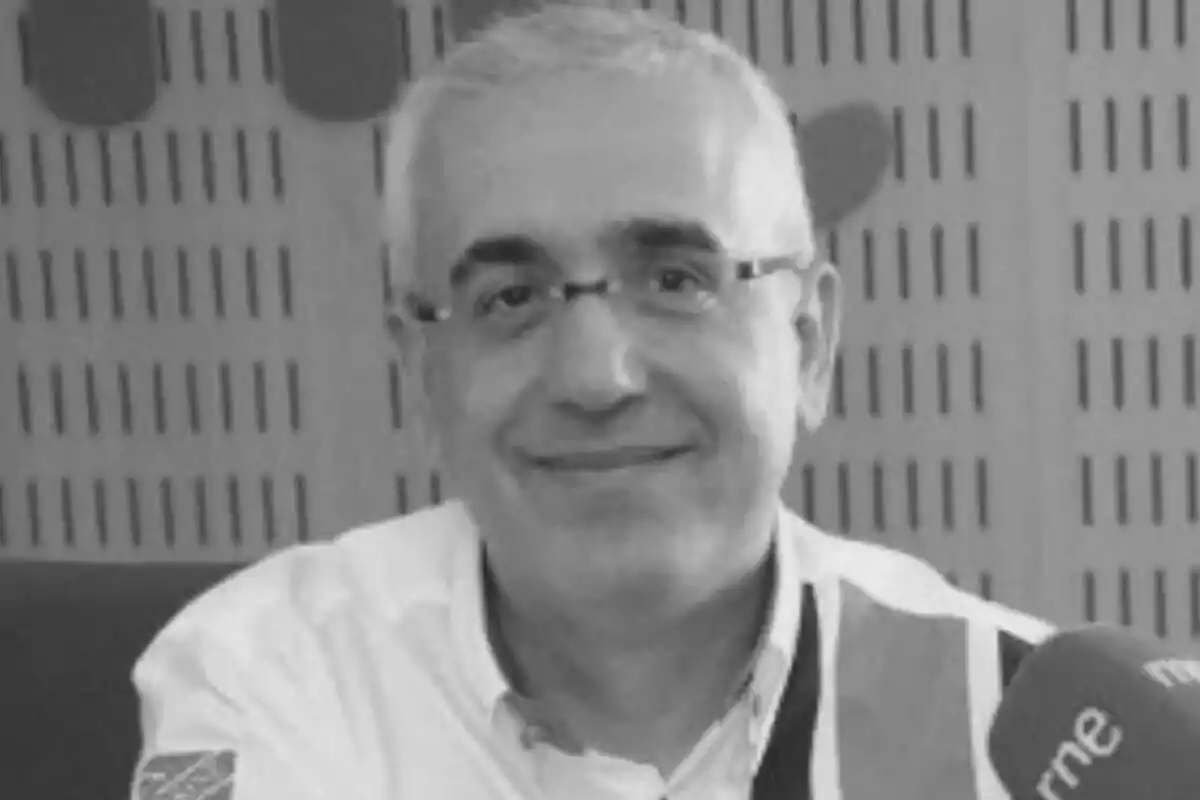 Domingo Álvarez con gafas sonríe frente a un micrófono en un estudio de grabación.