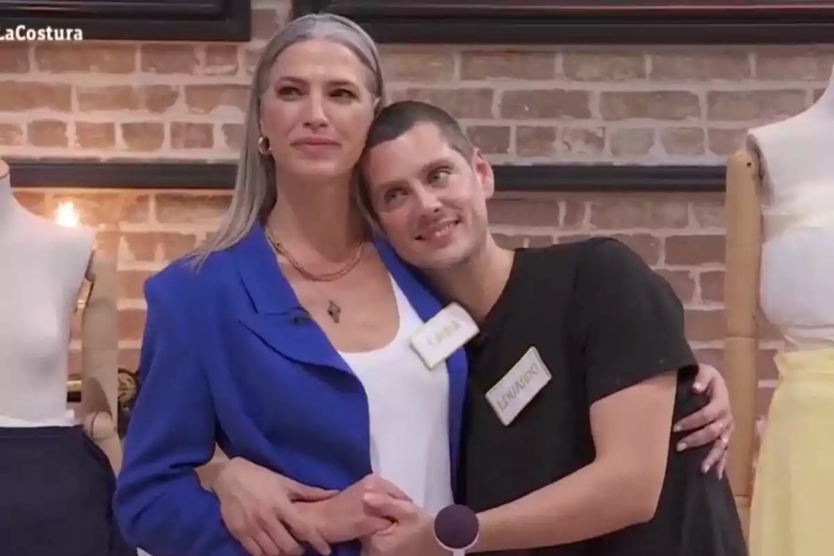 Eduardo Casanova y Laura Sánchez posan juntas en un entorno de costura, una de ellas lleva una chaqueta azul y la otra una camiseta negra, ambos en 'Maestros de la Costura Celebrity'