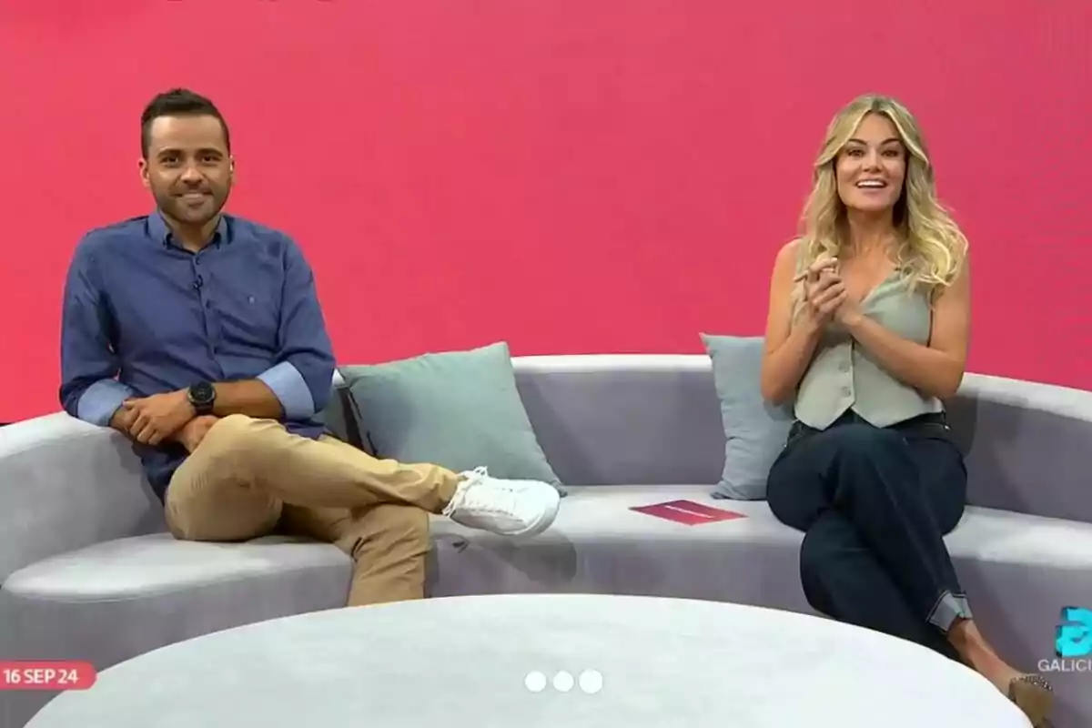 Rocio Delgado y otro hombre sentadas en un sofá gris con cojines, frente a un fondo rojo, una de ellas lleva una camisa azul y pantalones beige, mientras que la otra lleva una blusa sin mangas gris y pantalones oscuros en el programa El Termómetro. Rocio Delgado y otro hombre sentadas en un sofá gris con cojines, frente a un fondo rojo, una de ellas lleva una camisa azul y pantalones beige, mientras que la otra lleva una blusa sin mangas gris y pantalones oscuros en el programa El Termómetro.