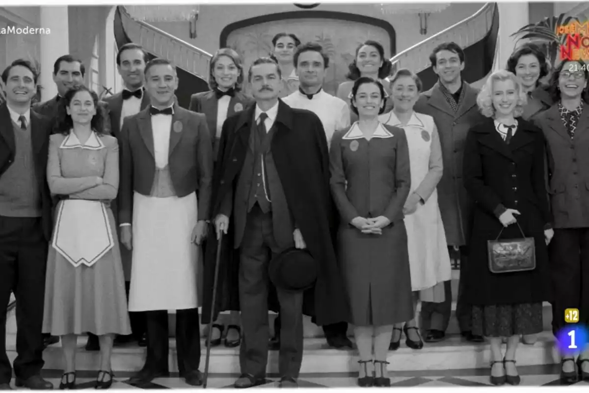 Todos los protagonistas de La Moderna posando en una escalera, algunas vestidas con uniformes de época, en una fotografía en blanco y negro. Todos los protagonistas de La Moderna posando en una escalera, algunas vestidas con uniformes de época, en una fotografía en blanco y negro.