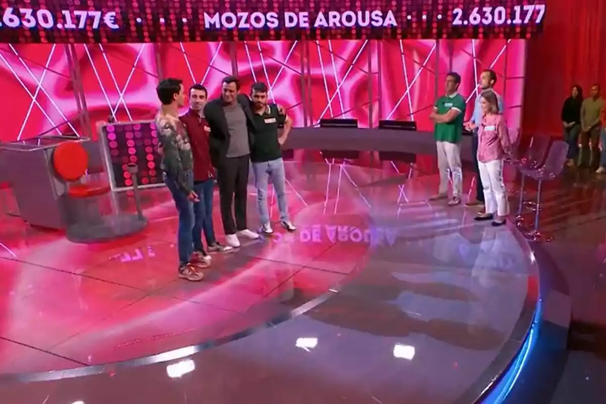 Borjamina, Bruno Vila y Raúl Santamaria, está de pie en Reacción en Cadena de un programa de televisión con un fondo rojo y un letrero que dice Borjamina, Bruno Vila y Raúl Santamaria, está de pie en Reacción en Cadena de un programa de televisión con un fondo rojo y un letrero que dice
