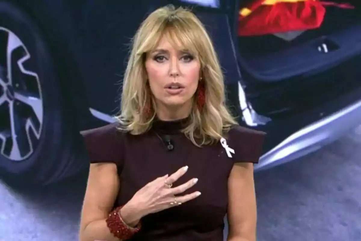 Emma García con vestido oscuro y lazo blanco en el pecho hablando frente a una imagen de un coche en Fiesta. Emma García con vestido oscuro y lazo blanco en el pecho hablando frente a una imagen de un coche en Fiesta.