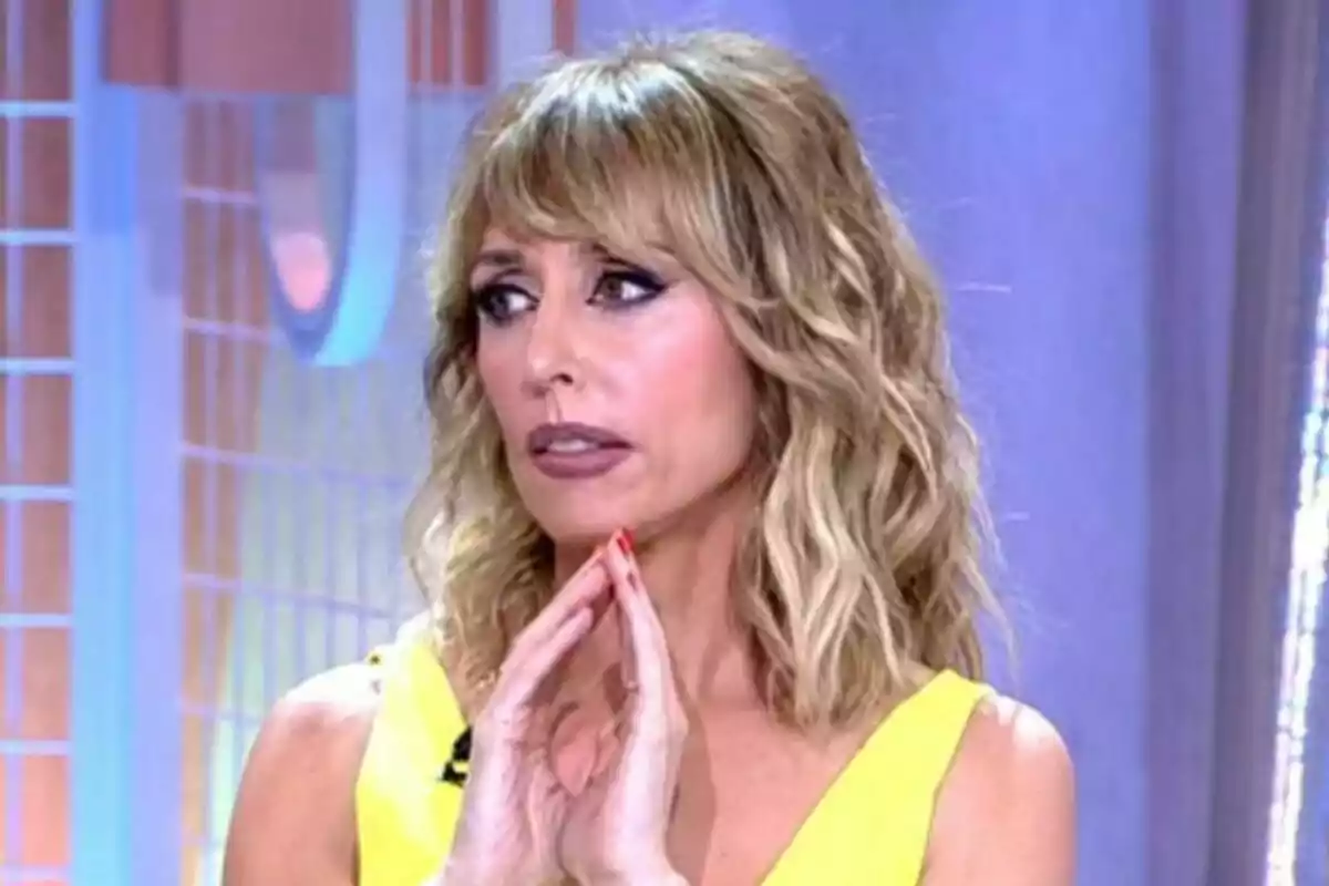 Emma García con cabello rubio y rizado en el plató de Fiesta con expresión pensativa. Emma García con cabello rubio y rizado en el plató de Fiesta con expresión pensativa.