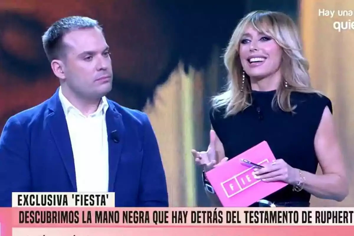 Saúl Ortiz y Emma García en un programa de televisión, una de ellas sostiene un sobre rosa con la palabra Saúl Ortiz y Emma García en un programa de televisión, una de ellas sostiene un sobre rosa con la palabra