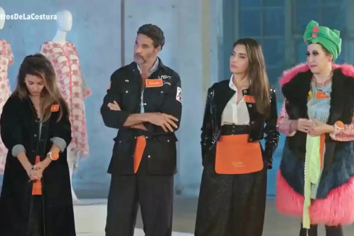 Mónica Cruz, Pilar Rubio, Óscar Higares y la Terremoto de Alcorcón de pie en un entorno de moda, con maniquíes al fondo, cada una con un atuendo distintivo y etiquetas con nombres en 'Maestros de la Costura Celebrity'. Mónica Cruz, Pilar Rubio, Óscar Higares y la Terremoto de Alcorcón de pie en un entorno de moda, con maniquíes al fondo, cada una con un atuendo distintivo y etiquetas con nombres en 'Maestros de la Costura Celebrity'.