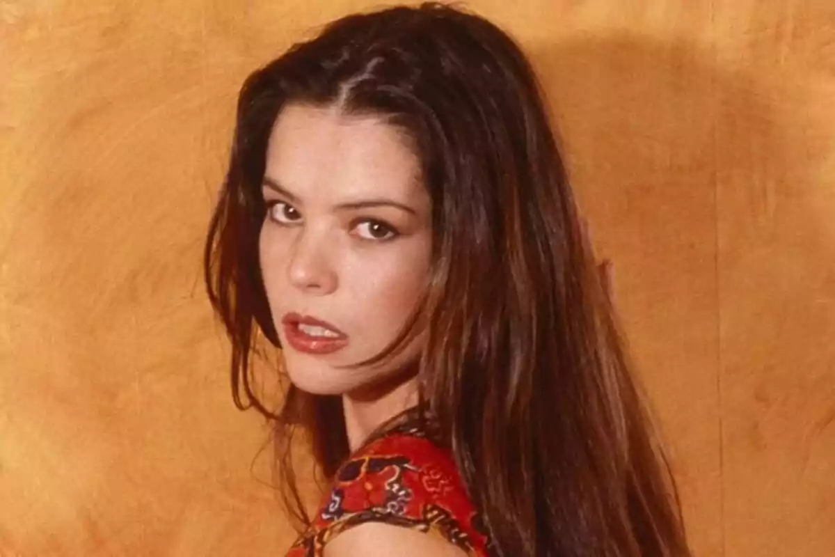 Fotografía de Esta TerBlanche con cabello largo y oscuro, vistiendo una blusa colorida, posando frente a un fondo de color marrón claro. Fotografía de Esta TerBlanche con cabello largo y oscuro, vistiendo una blusa colorida, posando frente a un fondo de color marrón claro.