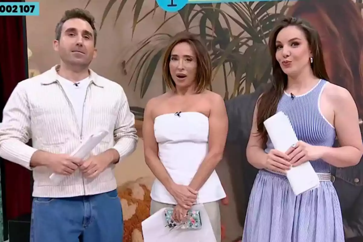 Tres presentadors de televisió, Aitor Albizua, María Patiño i Inés Hernand, posen junts en un plató decorat de La Família de la Tele amb plantes i un fons beix, cadascun sosté papers a les mans i vesteixen roba casual i elegant. Tres presentadors de televisió, Aitor Albizua, María Patiño i Inés Hernand, posen junts en un plató decorat de La Família de la Tele amb plantes i un fons beix, cadascun sosté papers a les mans i vesteixen roba casual i elegant.