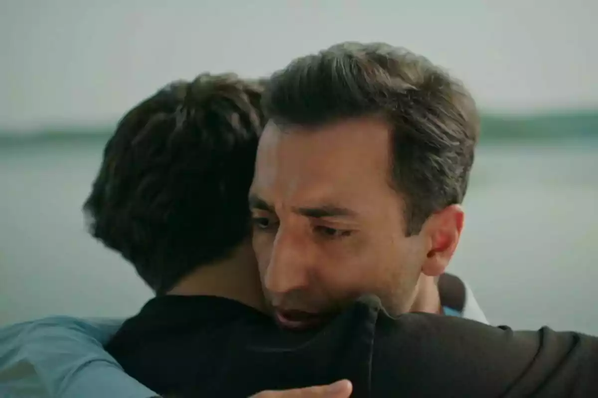 Ferit y Fuat abrazándose con expresión de emoción en un entorno al aire libre en Una nueva vida.