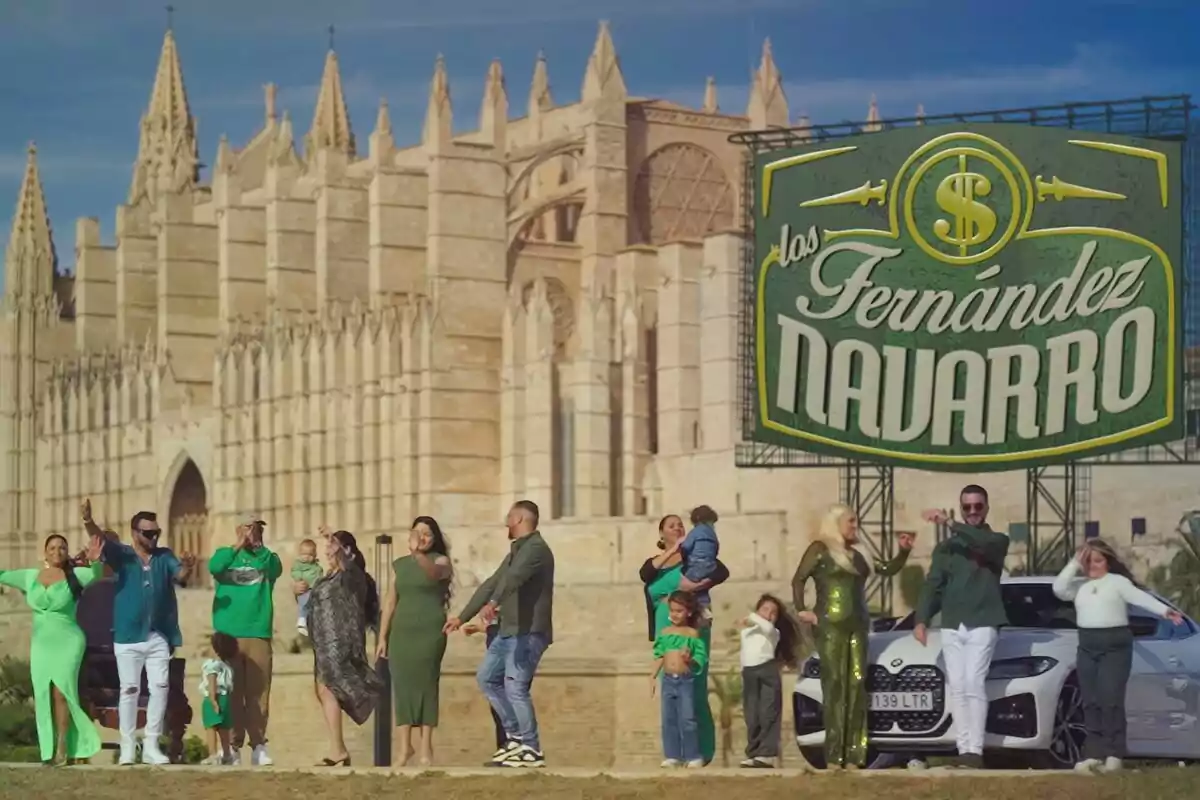 Un grupo de personas posando frente a una catedral con un cartel grande que dice 