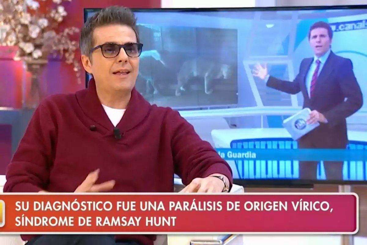 Fernando Díaz de la Guardia amb ulleres i jersei vermell està assegut a 'La tarda, aquí i ara', mentre al fons es veu una pantalla amb un presentador de notícies. Fernando Díaz de la Guardia amb ulleres i jersei vermell està assegut a 'La tarda, aquí i ara', mentre al fons es veu una pantalla amb un presentador de notícies.