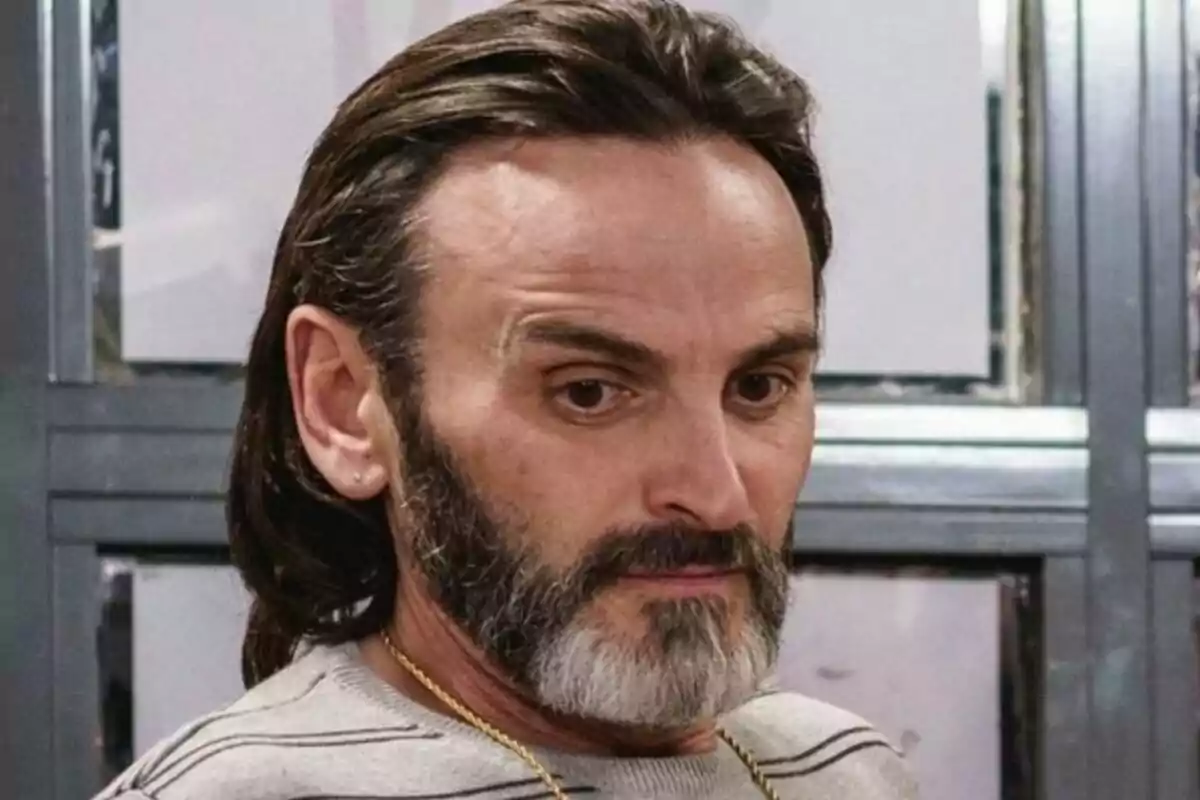 Fernando Tejero como Fermín Trujillo con barba y cabello largo mirando hacia abajo con expresión seria en La que se avecina. Fernando Tejero como Fermín Trujillo con barba y cabello largo mirando hacia abajo con expresión seria en La que se avecina.