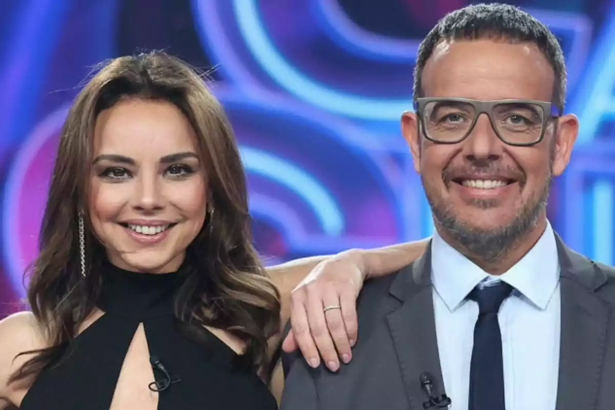 Chenoa y Àngel Llàcer sonrientes posando juntas en el plató de Tu Cara Me Suena con fondo colorido. Chenoa y Àngel Llàcer sonrientes posando juntas en el plató de Tu Cara Me Suena con fondo colorido.