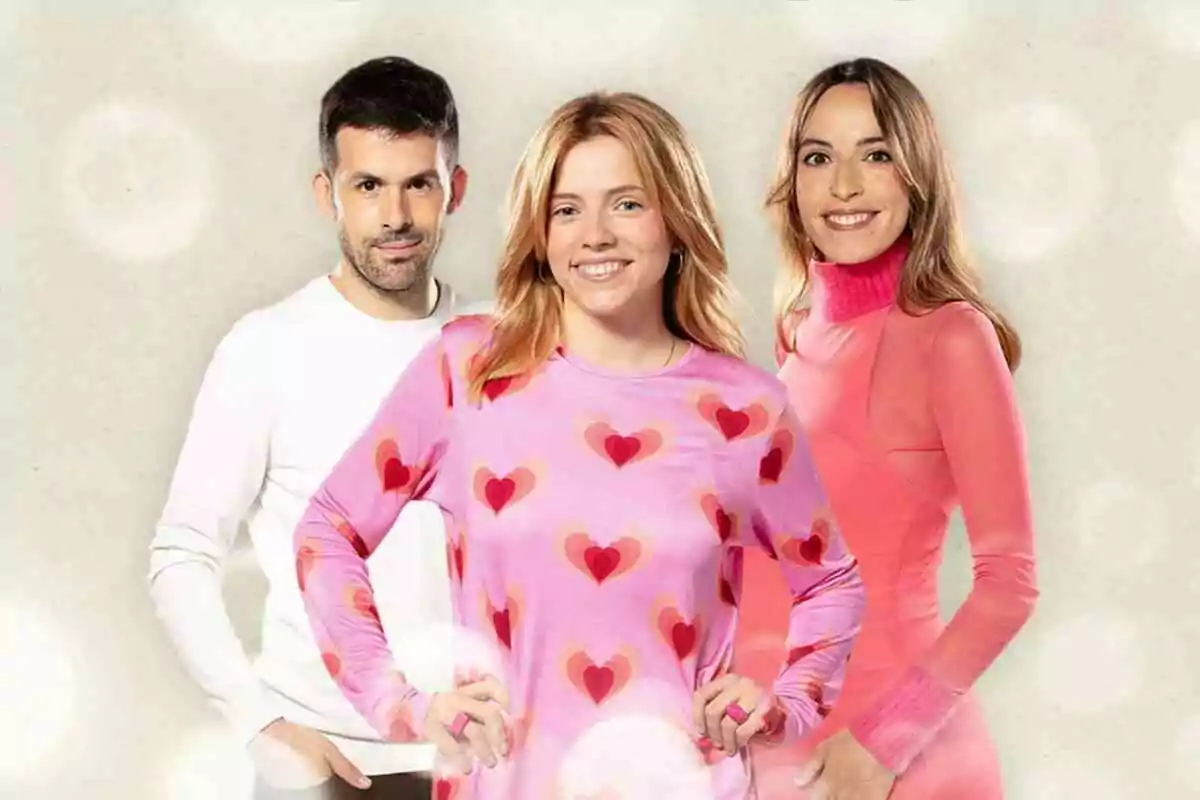 Roger Carandell, Juliana Canet i Marta Montaner posant junts, Juliana al centre amb una samarreta rosa amb cors, Roger a l'esquerra amb jersei blanc i Marta a la dreta amb un vestit rosa.