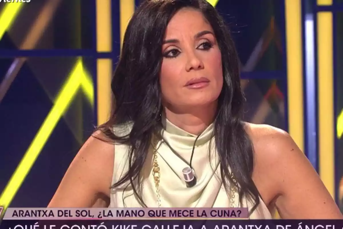 Foto de Ana Herminia en un plató de televisión hablando con cara seria y mirando de lado usando el cabello suelto y largo con una blusa blanca Foto de Ana Herminia en un plató de televisión hablando con cara seria y mirando de lado usando el cabello suelto y largo con una blusa blanca