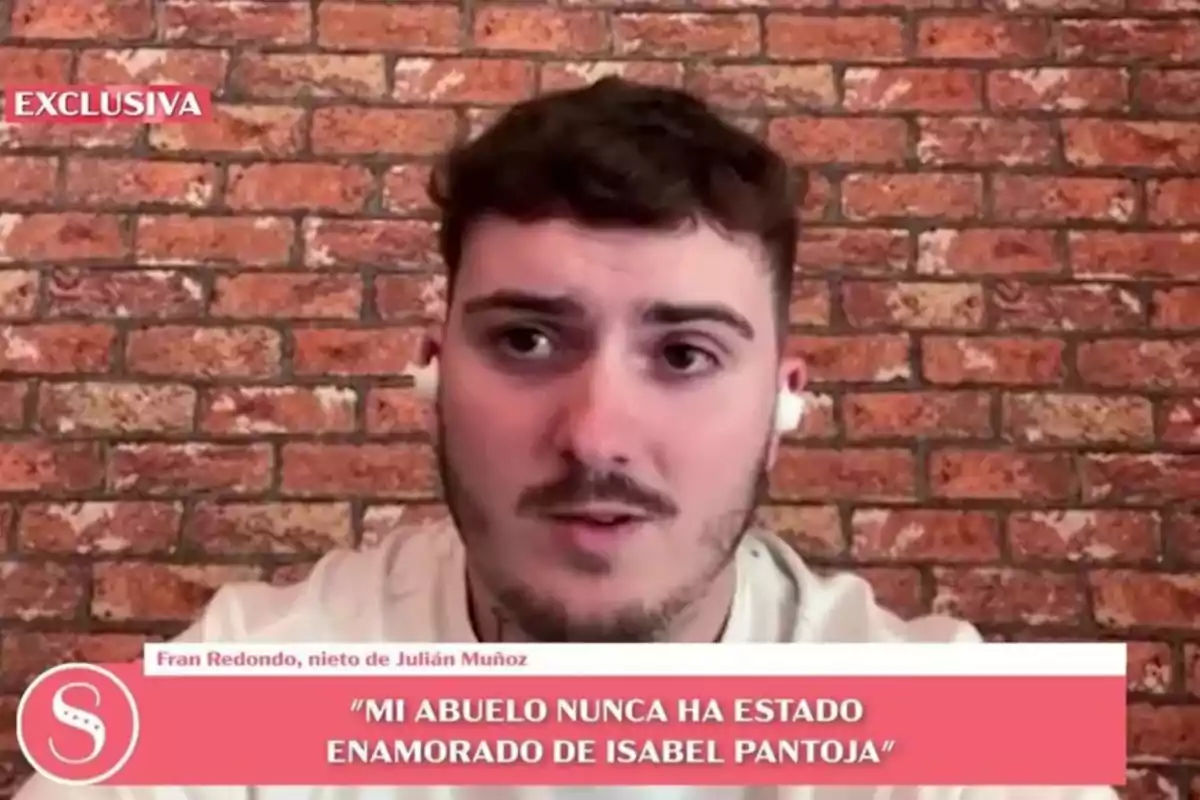 Fran Redondo con auriculares aparece en una entrevista televisiva con un fondo de ladrillos y un texto en pantalla que dice que su abuelo nunca ha estado enamorado de Isabel Pantoja.