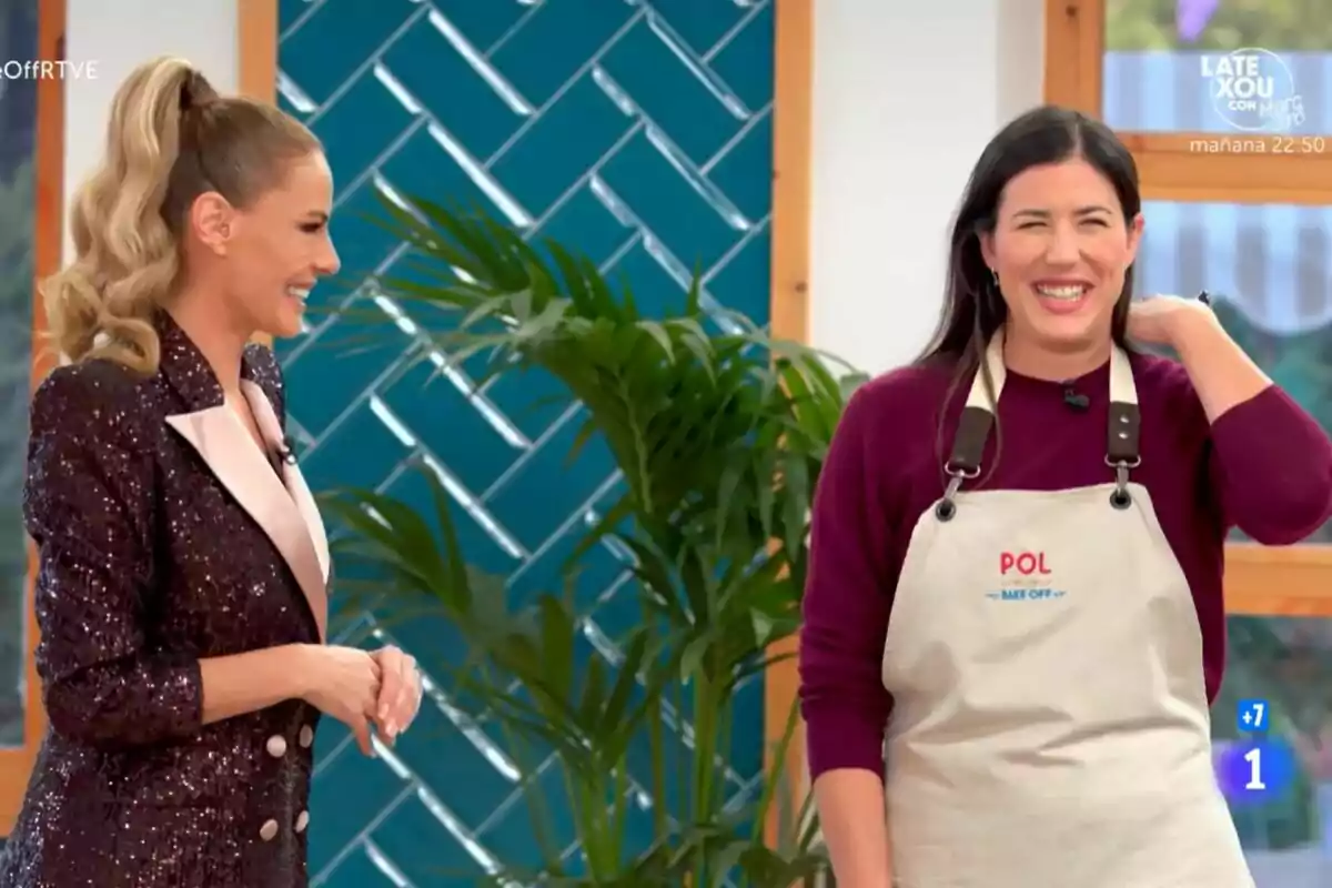 Garbiñe Muguruza i Paula Vázquez somriuen mentre conversen en un plató de televisió decorat amb plantes i un fons blau a Bake Off: Famosos al forn. Garbiñe Muguruza i Paula Vázquez somriuen mentre conversen en un plató de televisió decorat amb plantes i un fons blau a Bake Off: Famosos al forn.