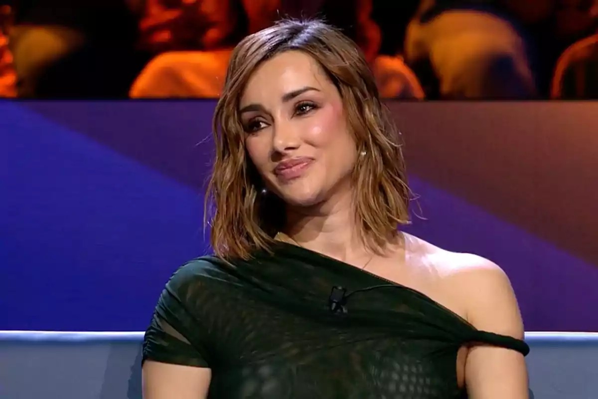 Adara Molinero con cabello castaño y ondulado, vestida con un top verde oscuro, está sentada en un plató de televisión con un fondo colorido. Captura de 'GH Dúo' Adara Molinero con cabello castaño y ondulado, vestida con un top verde oscuro, está sentada en un plató de televisión con un fondo colorido. Captura de 'GH Dúo'